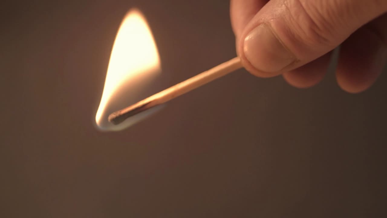 mano con un fósforo en llamas