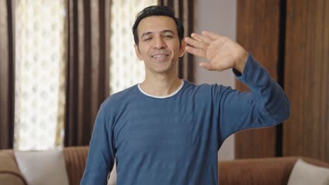 Happy-middle-aged-Indian-man-saying-Hi-and-waving-hand