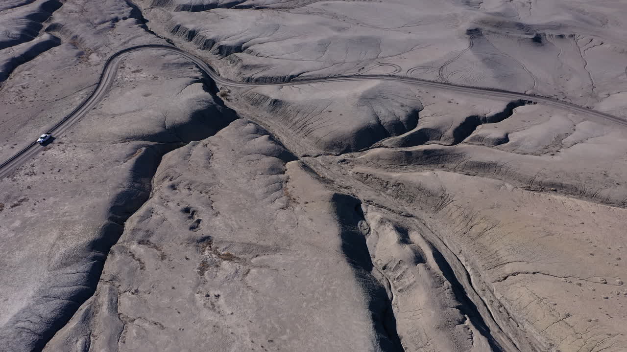 camión blanco viaja por carretera sin pavimentar en el desierto, vista de drones de gran ángulo