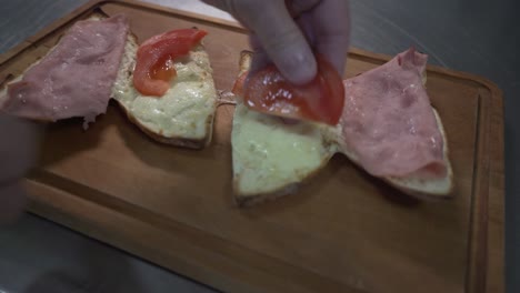 Making-sandwiches-with-cheese,-ham,-lettuce-and-tomato