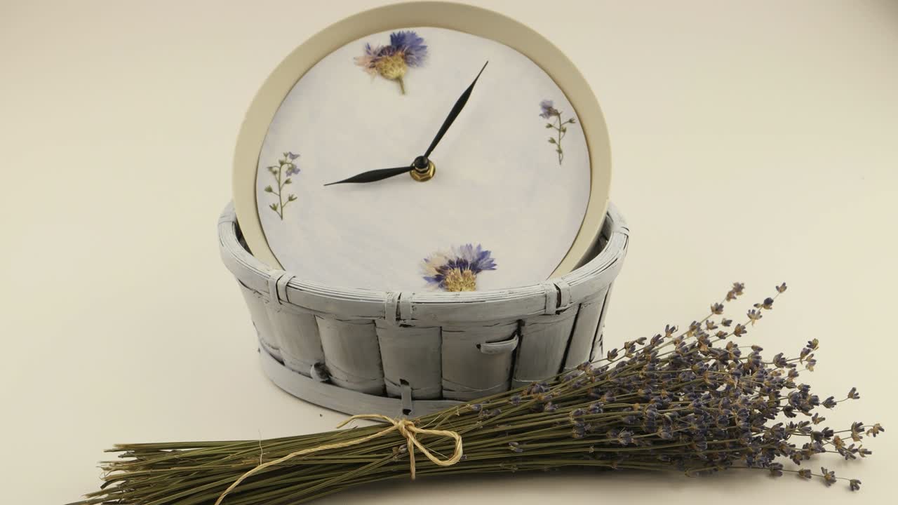 Klokke i den lyseblå flettekurven og bukett med tørkede lavendelblomster
