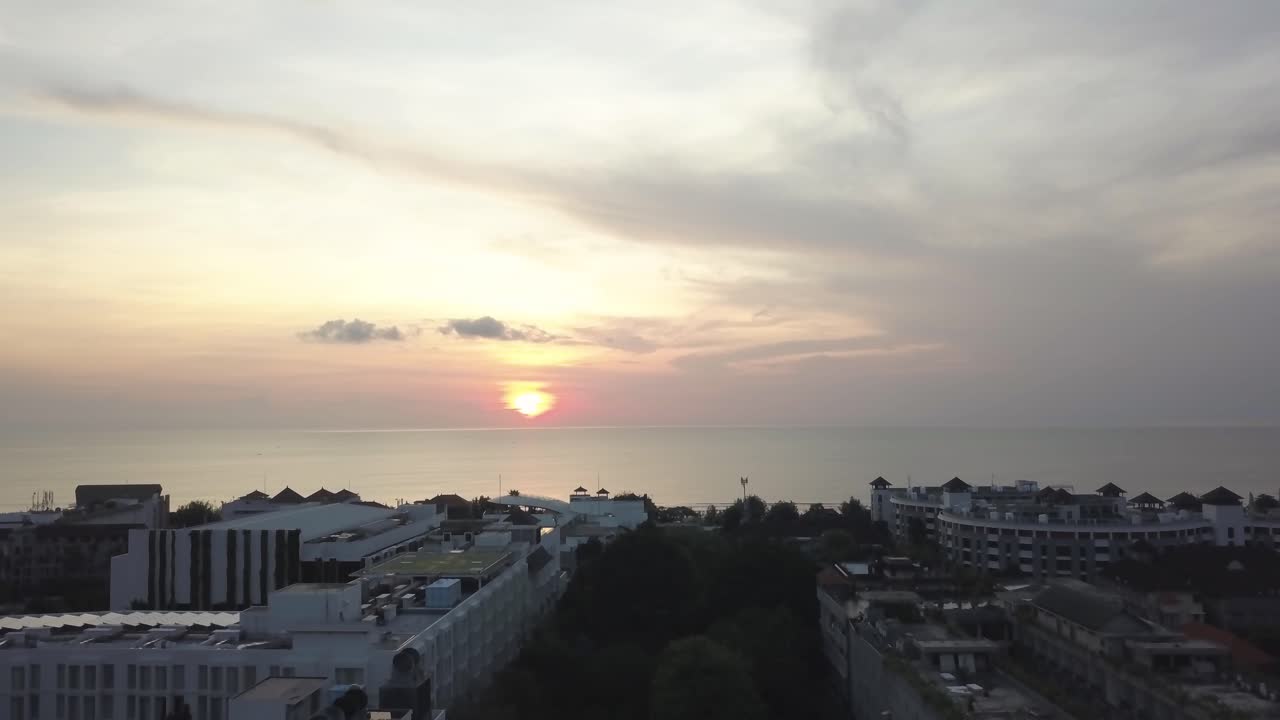 호텔과 함께 해변 도시 위에 해가 지는