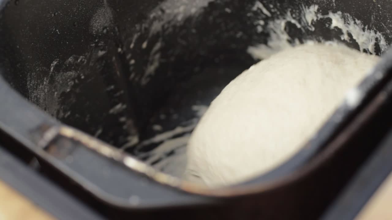 Smooth white dough turning in a bread machine