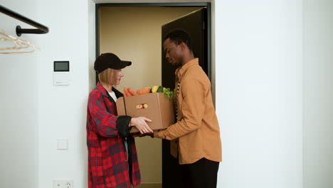 man receiving box of vegetables