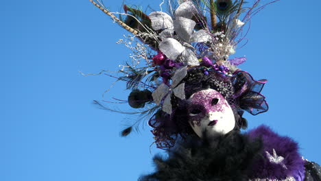 woman wearing colorful headdress with silver butterflies and volto mask