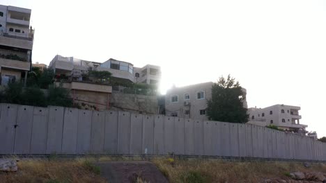 palestine refugges camp behind concrete wall with sun flares-aerial