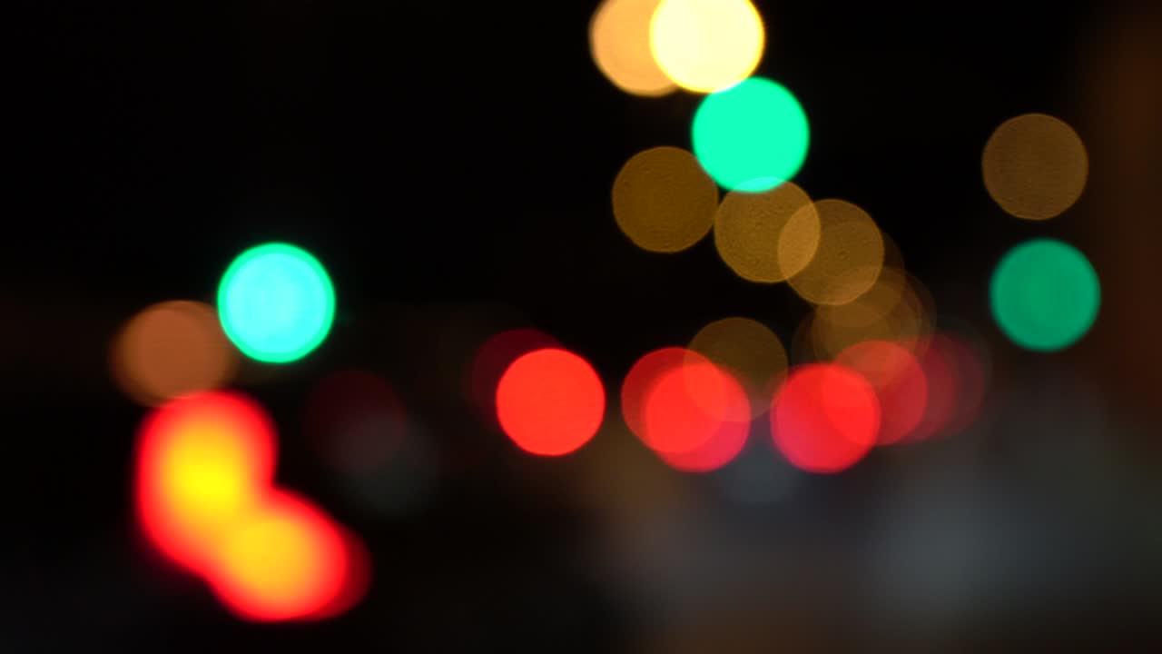 escena nocturna con luces borrosas de automóviles y semáforos