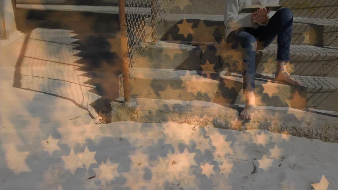 Girl sitting on steps turning pages as star shaped overlay receding revealing headset and studying