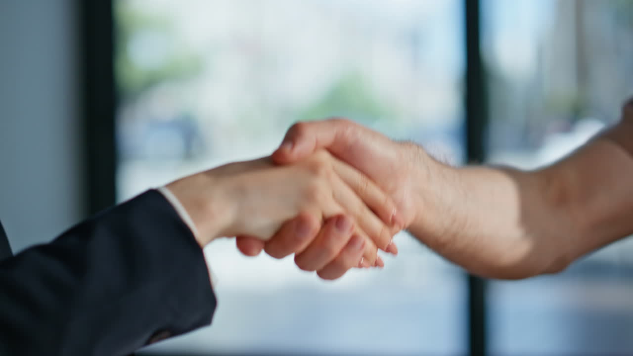 Unknown business partners shaking hands in office closeup. Trustworthy handshake