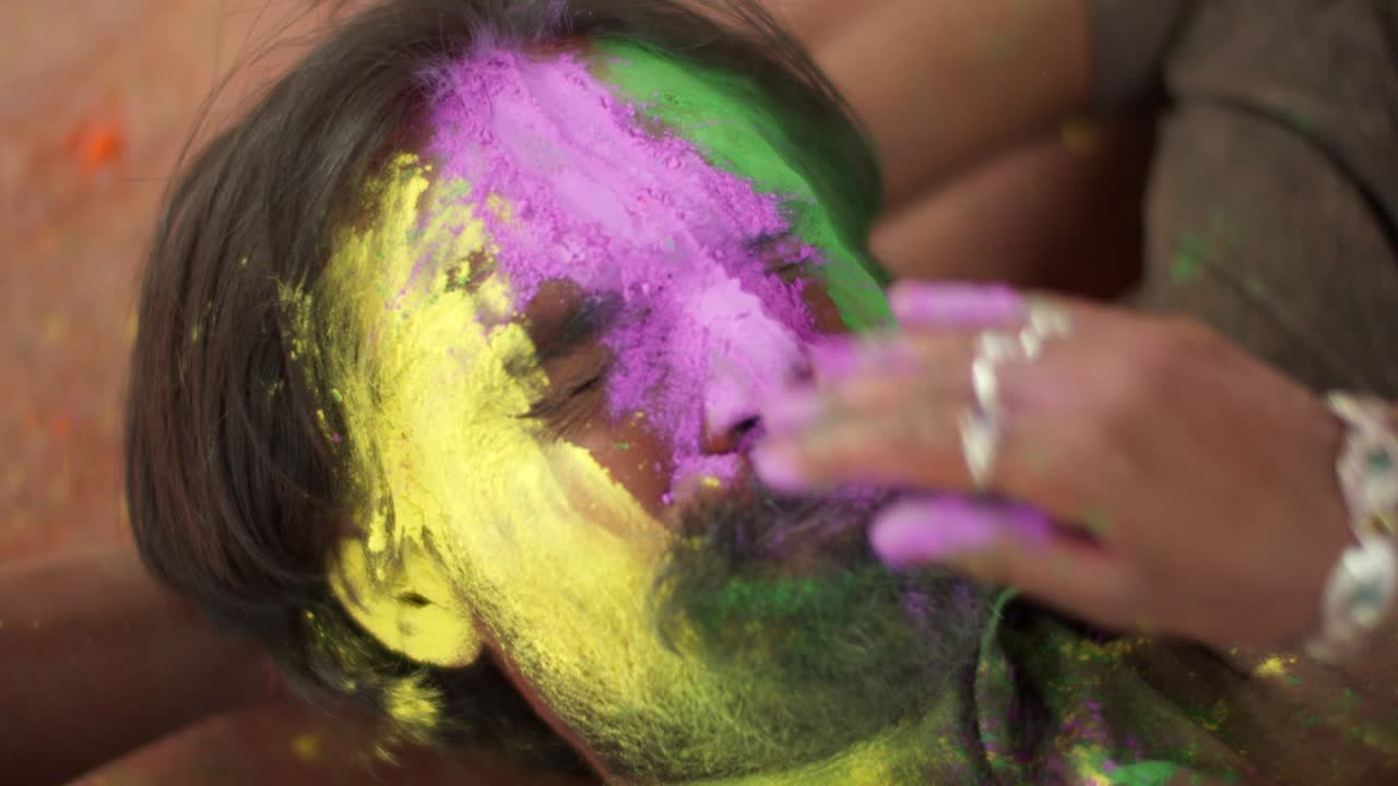 hombre indio de primer plano de la cara manchada con colores brillantes de holi