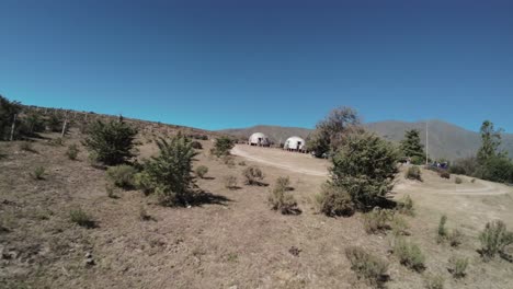 FPV-drone-view-of-boats-on-the-shore-of-La-Angostura-dam-in-luxury-cabin-hotel