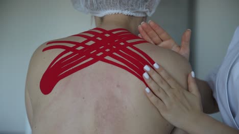Physical Therapist Applies Kinesio Taping to Man Knee Physical Therapist Applies Kinesio Taping to Man Knee Sports Knee Injuries and Treatment