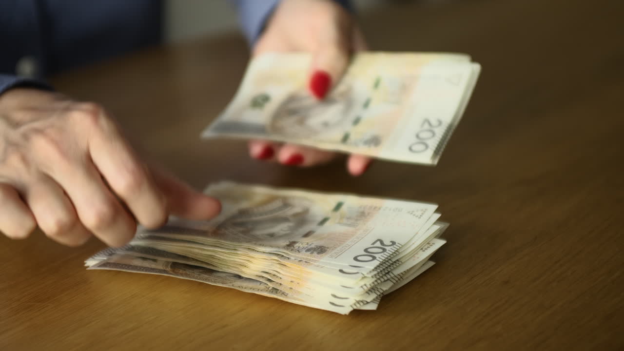 manos femeninas contando billetes de 200 zlotys polacos en la mesa - banca, negocios y finanzas concepto, primer plano