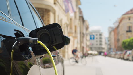 charger plugged into an electric car parked on the street, close up shot