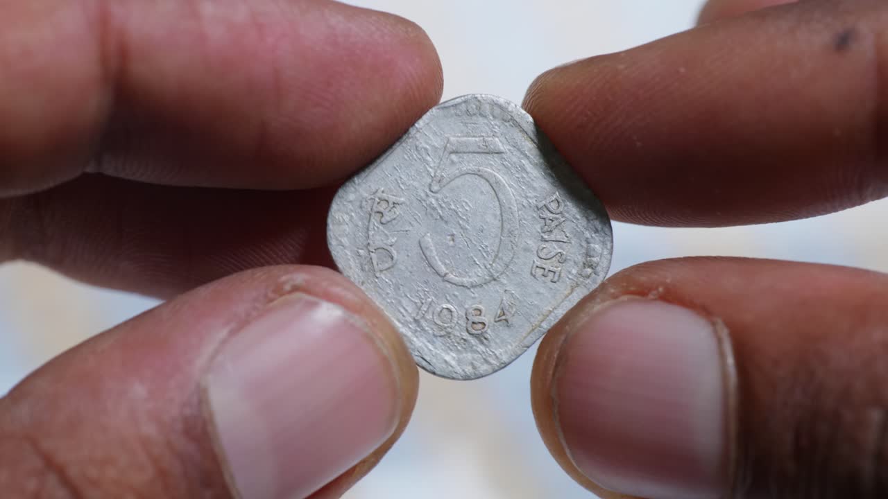 Person showing 1984 five paise coin of indian currency with national emblem of india. internal shot, mid shot, stable shot, 4k.