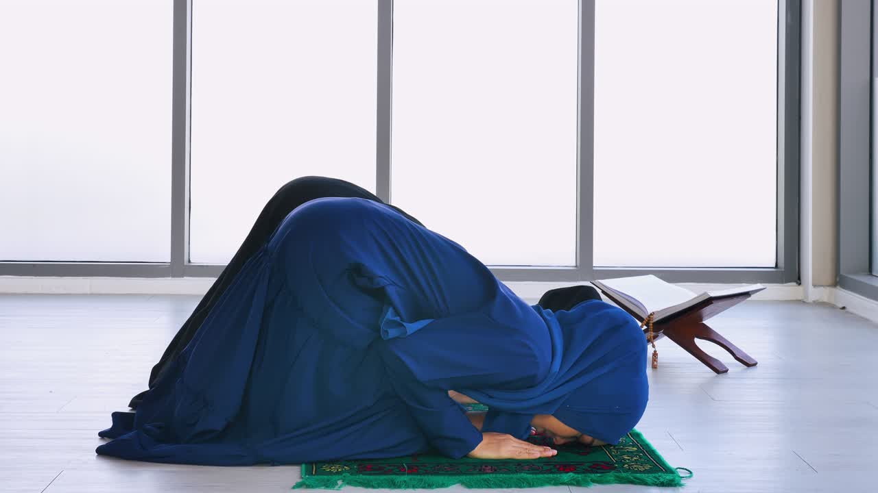 Geleneksel hicaplarıyla camide dua eden, Allah'ı yücelten ve İslam inancını uygulayan iki Asyalı Müslüman genç kadın