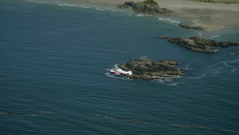 Toma-En-Gran-Angular-De-Un-Pequeño-Avión-Que-Volaba-Sobre-Una-Costa-Rocosa