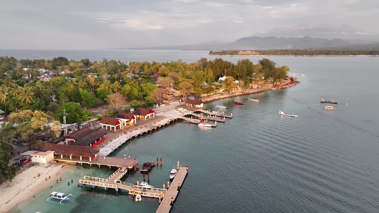 Beachfront with ferry terminal in Gili Air Island, Indonesia. Boats by sandy beach, tropical.