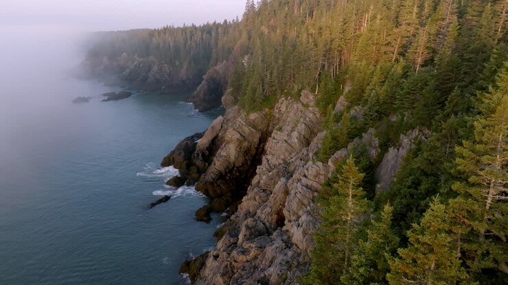 Gorgeous Descending Aerial View of Rocky Maine Coastline at Dawn with Purple Glow