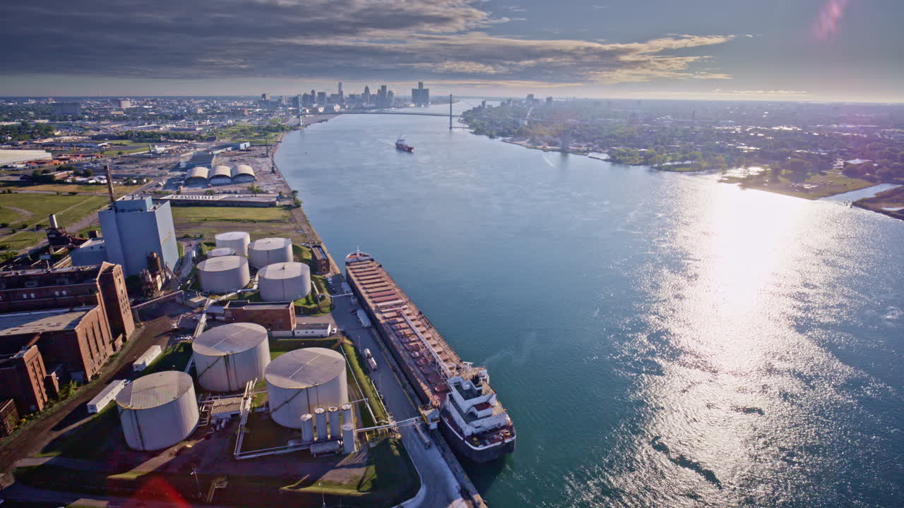Aerial drone captures the span of the Gordie Howe Bridge leading into an industrial backdrop