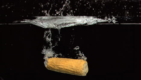 corn cob dropped into water in super slow motion