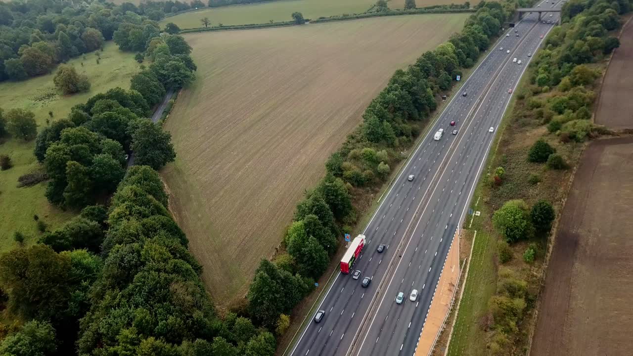 Drone above M1 Motorway with light traffic panning to face south