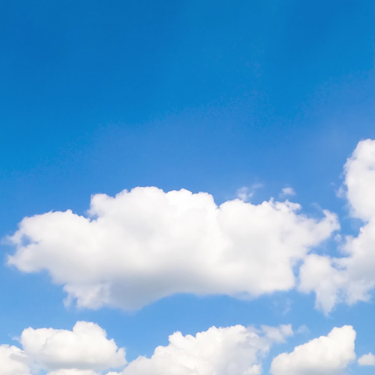 Amazingly beautiful azure sky with some white clouds. Cotton clouds changing shapes quickly. Low angle view. Timelapse