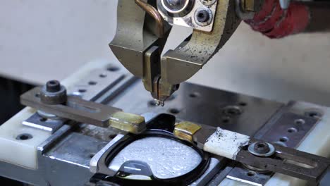 eyewear manufacturing process: close-up of machine assembling glasses frames