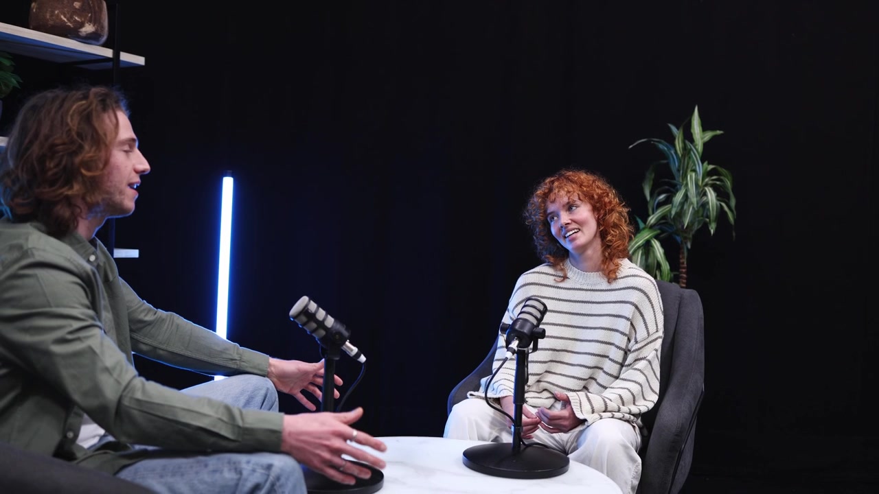 To personer i en podcast-samtale i et moderne studie
