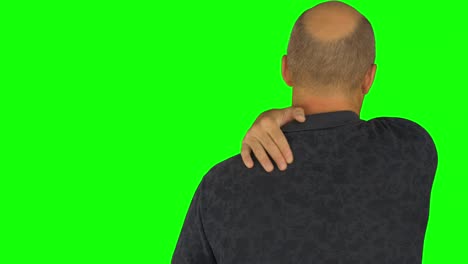 man stroking his shoulders with right hand. back view waist up in polo shirt.