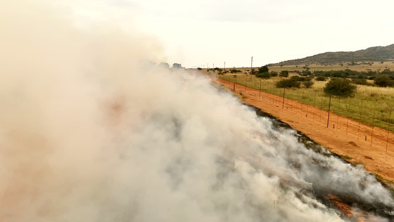 Drone flies into smoke as firefighters monitor roadside vegetation clearing burn