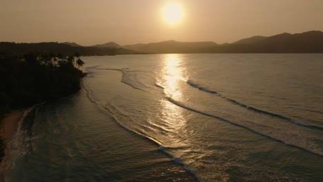 sunset on the shore of a tropical beach in the dominican republic, aerial forward