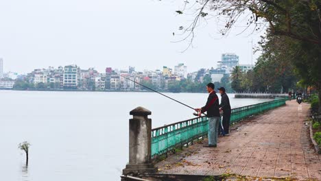 two people fishing by a serene lakeside