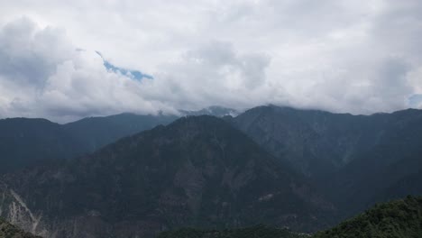 time-lapse of clouds drifting above dark forested mountains in the kashmir himalayas. neelum valley