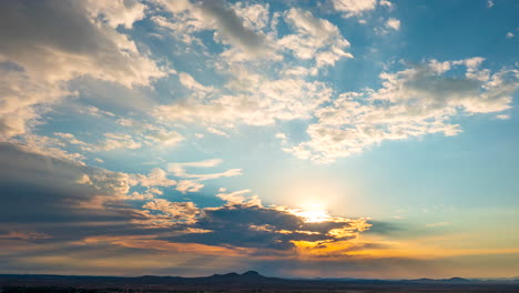 aerial time lapse over the mojave desert with the sunshine bursting through the clouds at sunrise