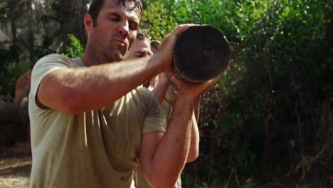 military troops carrying heavy wooden log during obstacle course 4k