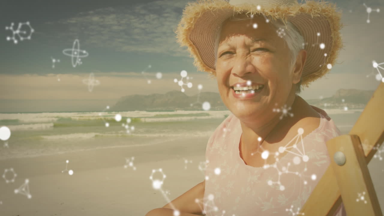 Smiling elderly woman on beach with molecular structure animation overlay