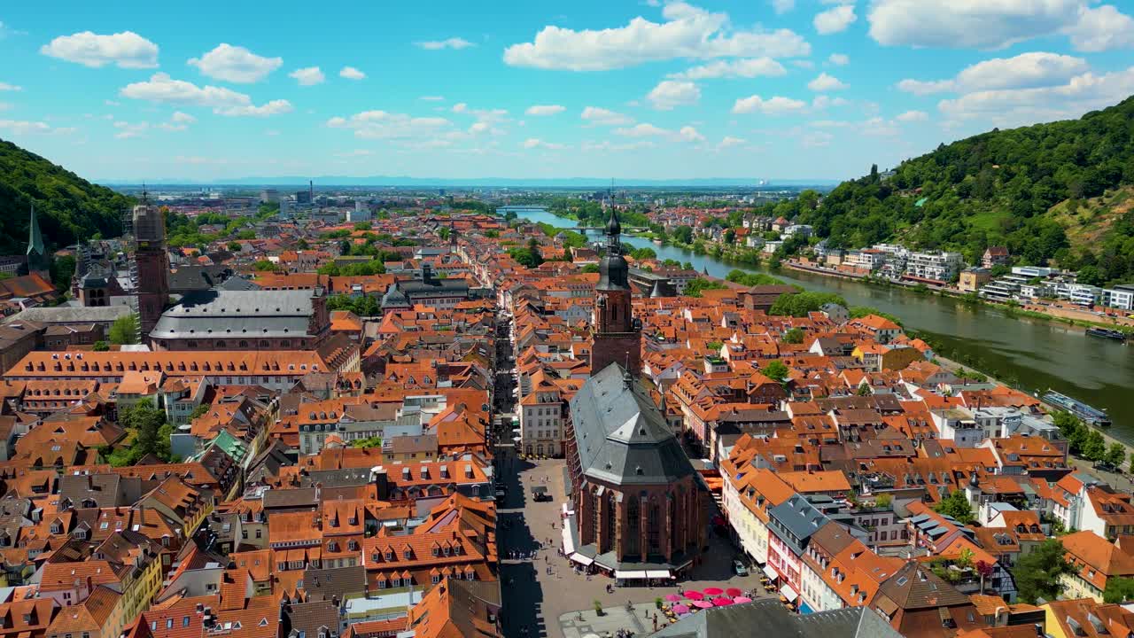 4K Aerial Drone Video of the Beautiful Homes with Red Terracotta Tile Roofs and Historic Heiliggeistkirche Church along the Neckar River in Heidelberg, Germany
