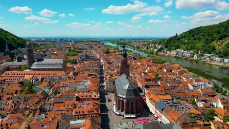 4K Aerial Drone Video of the Beautiful Homes with Red Terracotta Tile Roofs and Historic Heiliggeistkirche Church along the Neckar River in Heidelberg, Germany