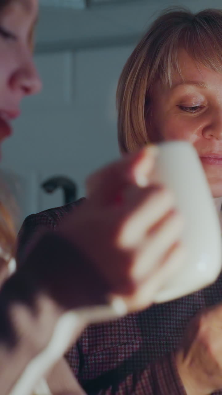 엄마와 아이가 잔을 어 기면서, 조용하고 친밀한 저녁을 함께 나누면서, 따뜻한 불빛은 위안의 빛을 더합니다.