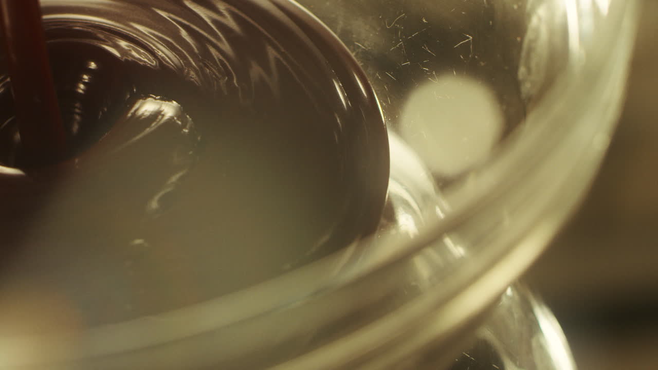 fondue de chocolate en primer plano goteando en un plato transparente.