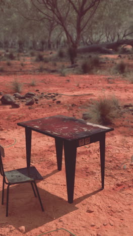 una mesa solitaria y una silla en un paisaje desértico