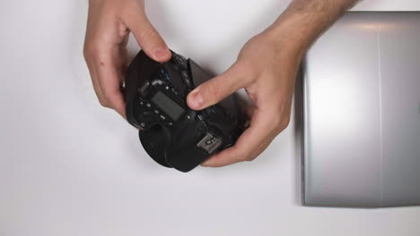 hand removes memory card from laptop and the returned to dslr camera