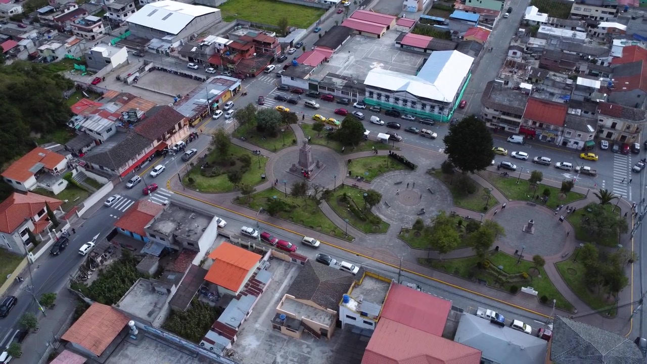 Ampia veduta aerea con drone sopra il centro città di Calacali con piazza, strade, traffico e il monumento Mitad del Mundo, Ecuador