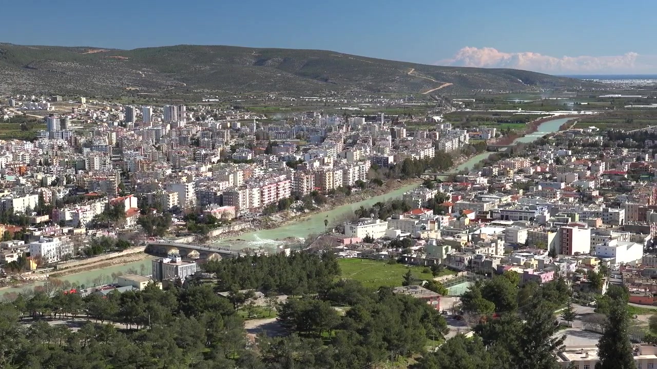 Nehir ve dağlarla çevrili bir şehrin kuşbakışı görünümü.