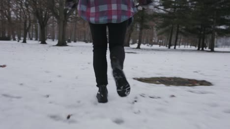 a person running swiftly on a park full of snow - close up shot
