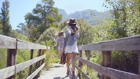 two beautiful friends on adventure trail wooden bridge looking at nature