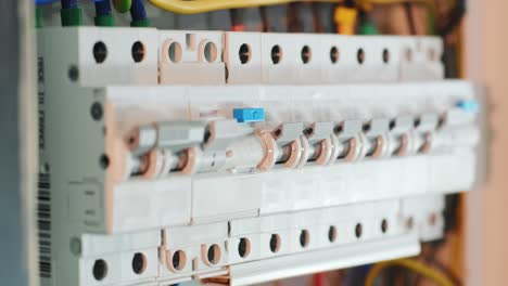 close-up of hand on switch of distribution board. man switching on fuseboard