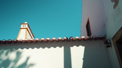 Chimenea-De-Techo-Típica-De-Portugal,-Casa-De-Paredes-Blancas,-Bajo-El-Cielo-Azul-Al-Sol-4k