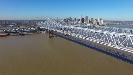 Toma-Aérea-Del-Puente-De-La-Ciudad-De-Crescent-Sobre-El-Río-Mississippi,-Revelando-El-Horizonte-De-Nueva-Orleans,-Luisiana-1